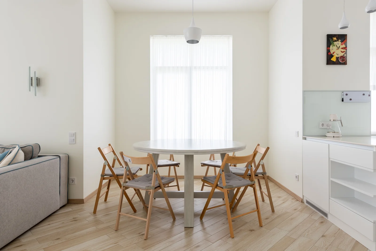 Photo d’ambiance : table ronde et quatre chaises en bois dans un coin repas clair